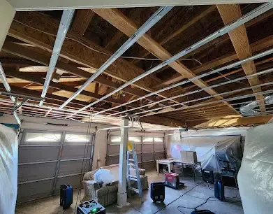 A garage ceiling cut open with drying equipment running below it