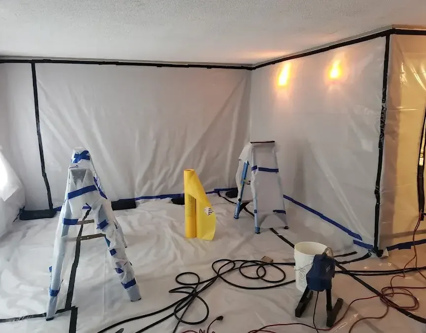 A room sealed off with plastic containment walls and floor covering ahead of the work