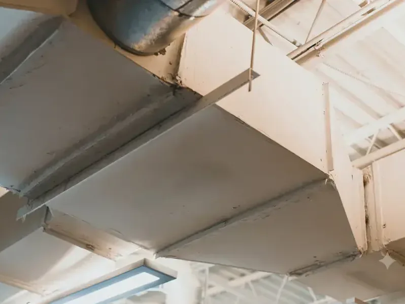 Attic ductwork over a ceiling stained brown where an air handler drain overflowed